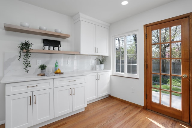 interior space with baseboards, recessed lighting, light wood-style flooring, and backsplash