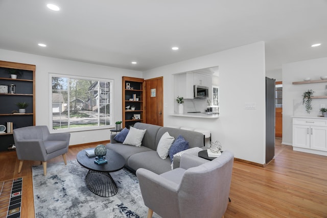 living room featuring light wood-type flooring, recessed lighting, and baseboards