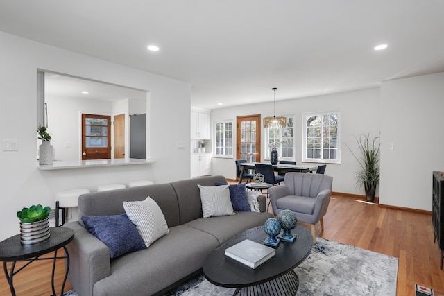 living area featuring recessed lighting, baseboards, and light wood-type flooring