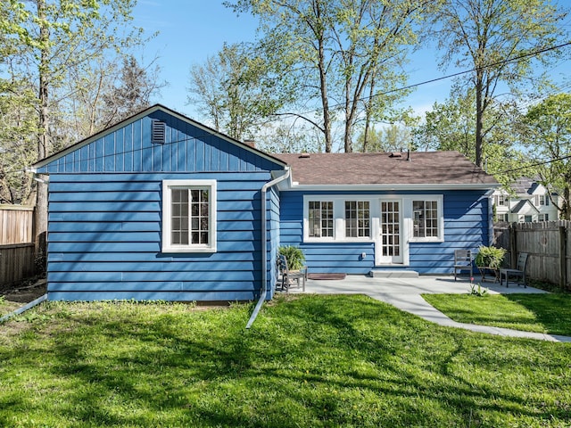 back of property featuring a lawn, fence, and a patio area