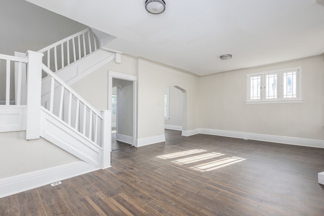 574 Melbourne St, Detroit, MI 48202 - unfurnished living room featuring arched walkways, baseboards, stairs, and wood finished floors