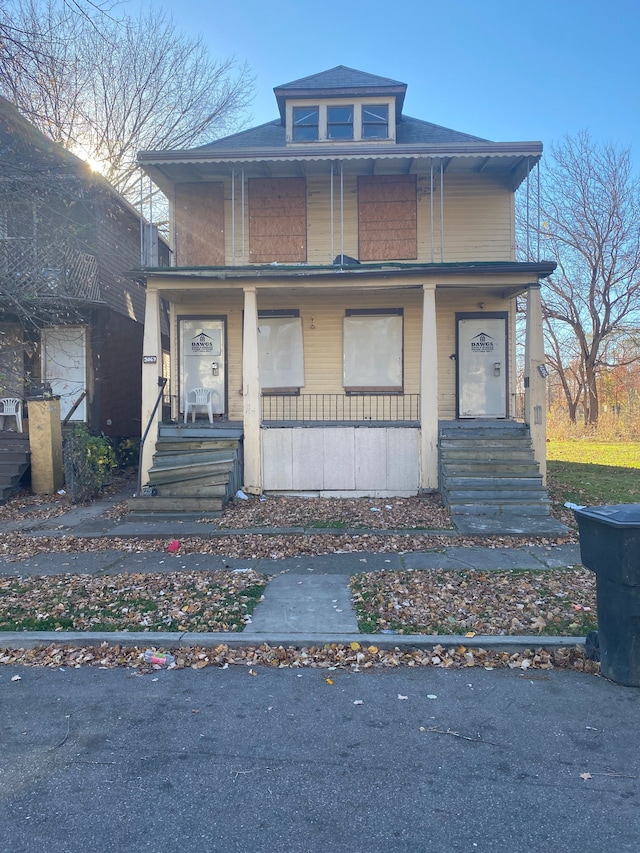 american foursquare style home featuring a porch