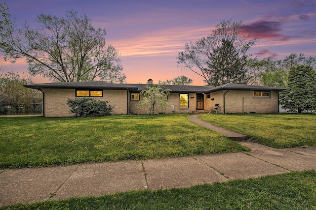 view of front facade featuring brick siding and a front yard