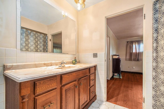 full bath featuring wainscoting, tile walls, vanity, and wood finished floors