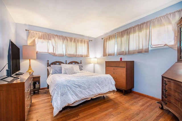 bedroom featuring baseboards and hardwood / wood-style floors