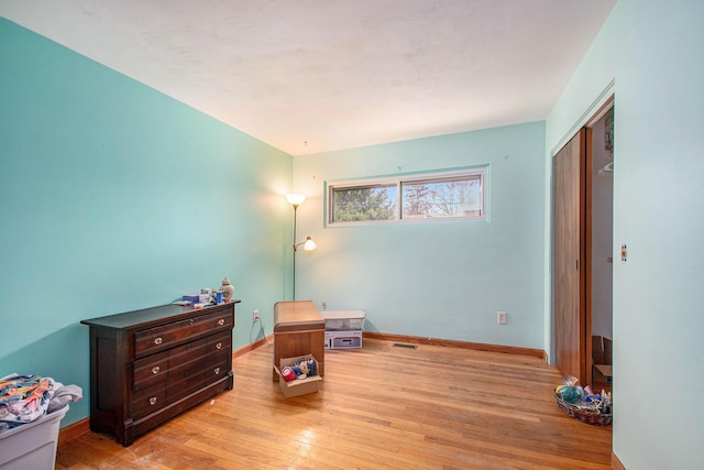 bedroom with light wood-type flooring, baseboards, and visible vents