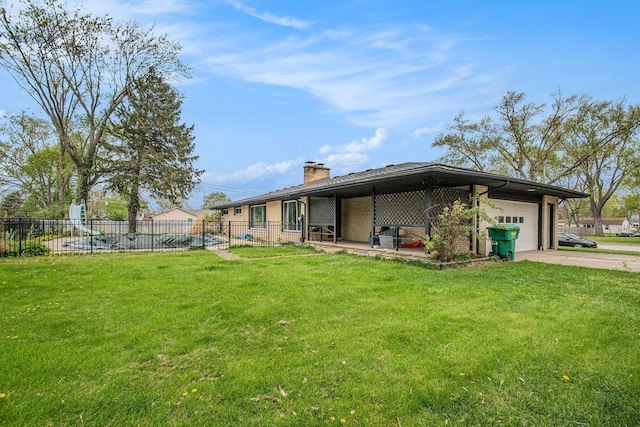 back of house featuring a yard, an attached garage, fence, and a chimney