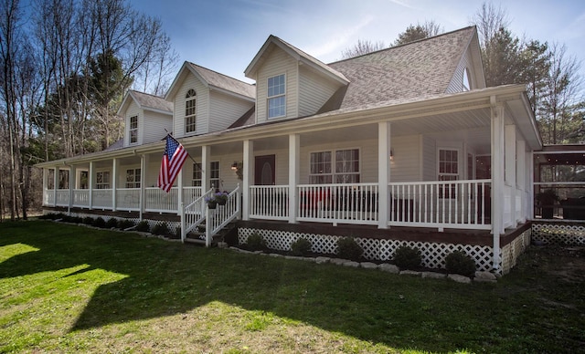 farmhouse inspired home featuring a porch, a front lawn, and roof with shingles