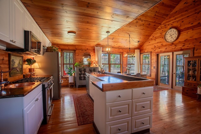 kitchen featuring wooden ceiling, stainless steel appliances, dark wood-style flooring, and white cabinetry