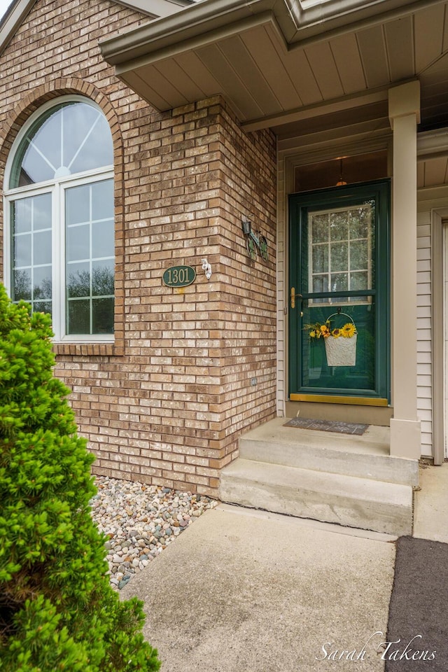 doorway to property with brick siding