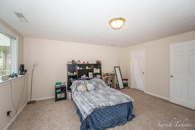bedroom with baseboards, light carpet, and visible vents