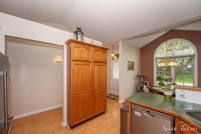 kitchen featuring stainless steel dishwasher, light wood-style flooring, and lofted ceiling