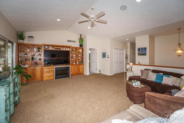 living area featuring visible vents, carpet floors, lofted ceiling, ceiling fan, and a textured ceiling