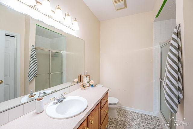 full bath with visible vents, a shower stall, vanity, baseboards, and toilet