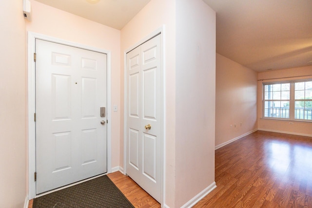 foyer with light wood-type flooring and baseboards