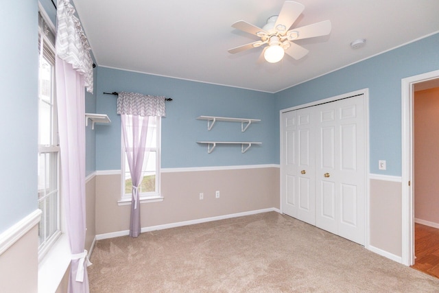 unfurnished bedroom with a ceiling fan, baseboards, carpet, and a closet
