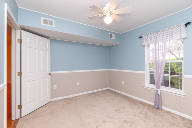 spare room featuring baseboards, ceiling fan, carpet flooring, and visible vents