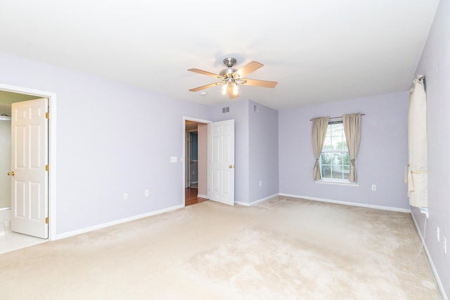 empty room with baseboards, a ceiling fan, visible vents, and light carpet