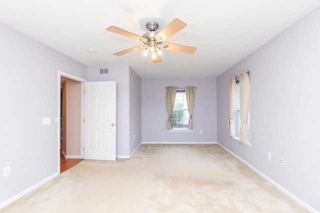 unfurnished bedroom featuring visible vents, baseboards, ceiling fan, and light carpet