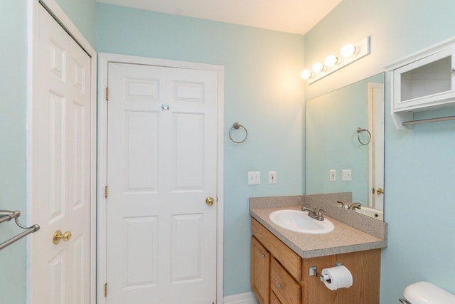 half bathroom with vanity and toilet