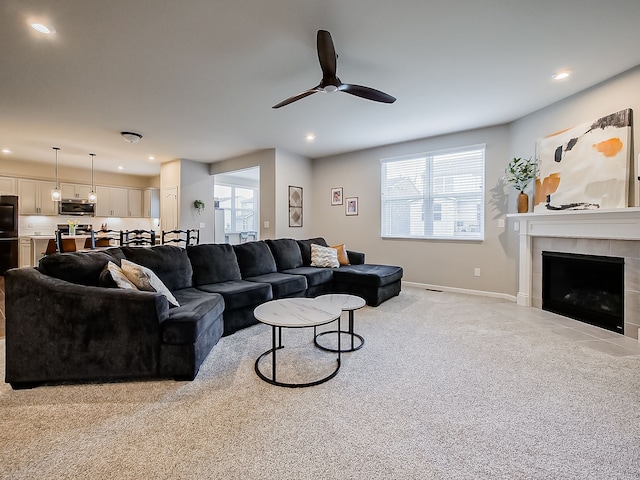 living area featuring light carpet, a ceiling fan, plenty of natural light, recessed lighting, and a fireplace