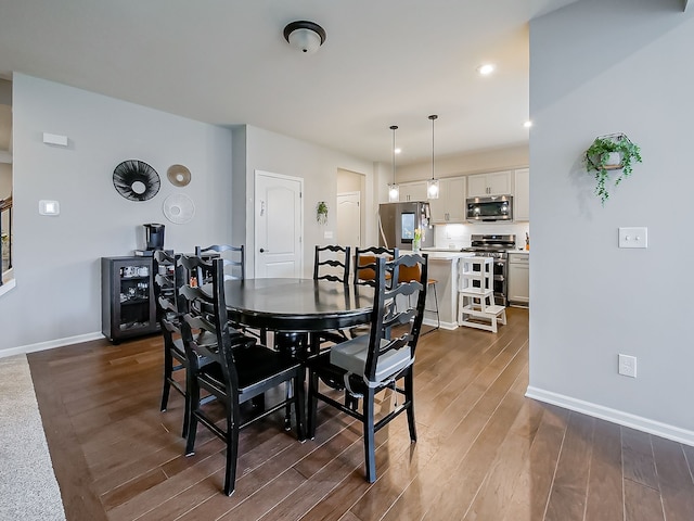 dining room with dark wood-style flooring, baseboards, and recessed lighting
