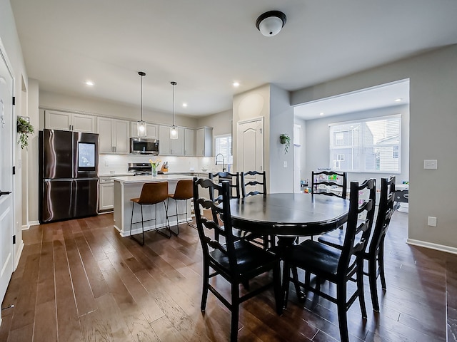 dining space with healthy amount of natural light, dark wood-style flooring, recessed lighting, and baseboards