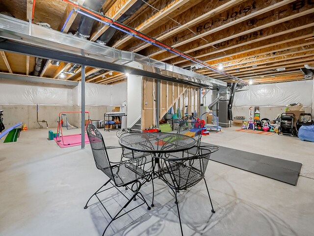 unfinished basement with heating unit and stairs