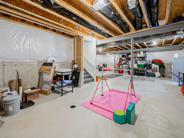 unfinished below grade area with freestanding refrigerator and stairway