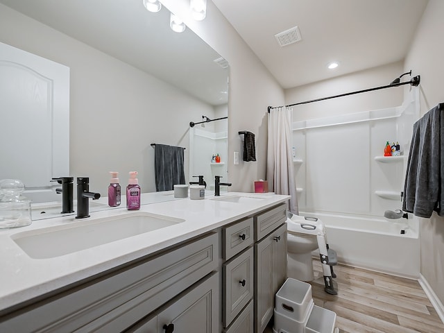 full bath with wood finished floors, shower / bathtub combination with curtain, double vanity, and recessed lighting