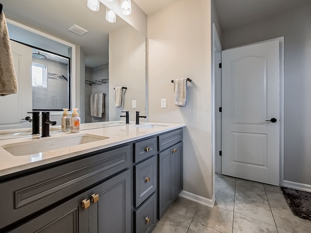 full bath featuring baseboards, double vanity, and tile patterned flooring