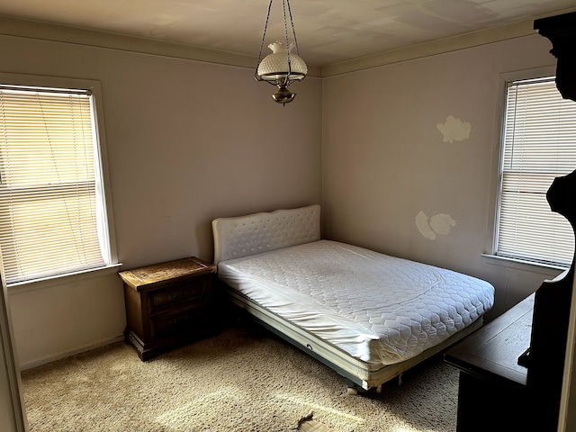 bedroom with baseboards, multiple windows, and light colored carpet