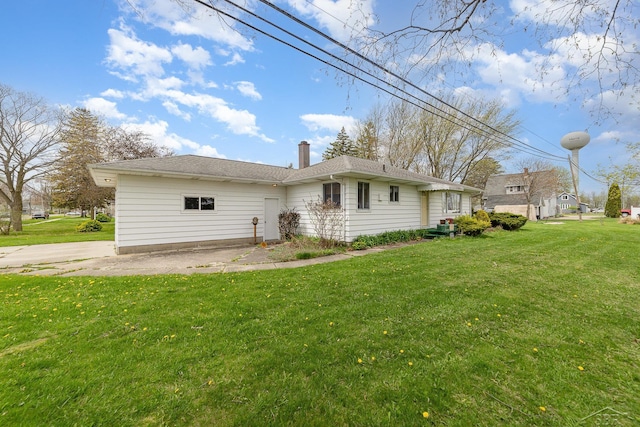 rear view of property with a lawn and a chimney