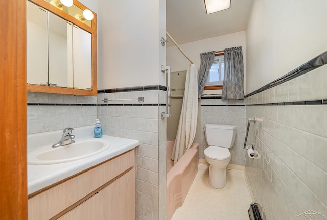 full bath with tile walls, vanity, toilet, and shower / tub combo