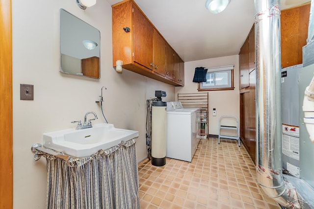laundry room featuring cabinet space, baseboards, washing machine and dryer, and a sink