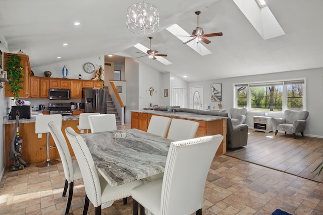 15756 Lewis Rd, Mussey, MI 48014 - dining area featuring stone tile floors, stairs, ceiling fan, high vaulted ceiling, and a skylight