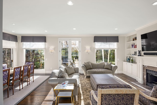 living room featuring recessed lighting, baseboards, ornamental molding, and a high end fireplace