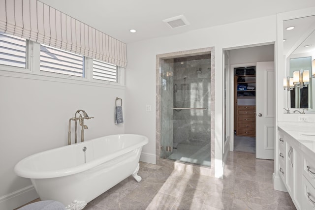 bathroom featuring vanity, baseboards, a freestanding bath, a spacious closet, and a shower stall