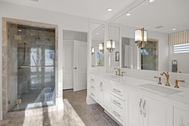 bathroom featuring a sink, a shower stall, and double vanity
