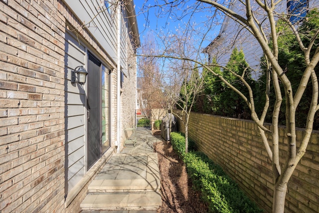 view of home's exterior with brick siding and fence