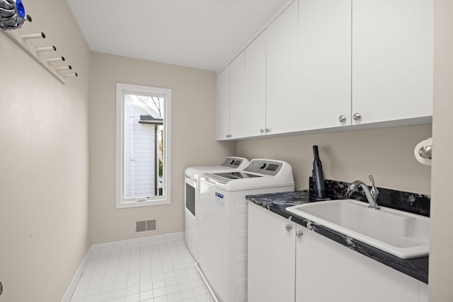 washroom featuring visible vents, cabinet space, a sink, baseboards, and separate washer and dryer