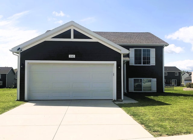 view of front of home with concrete driveway, an attached garage, and a front lawn