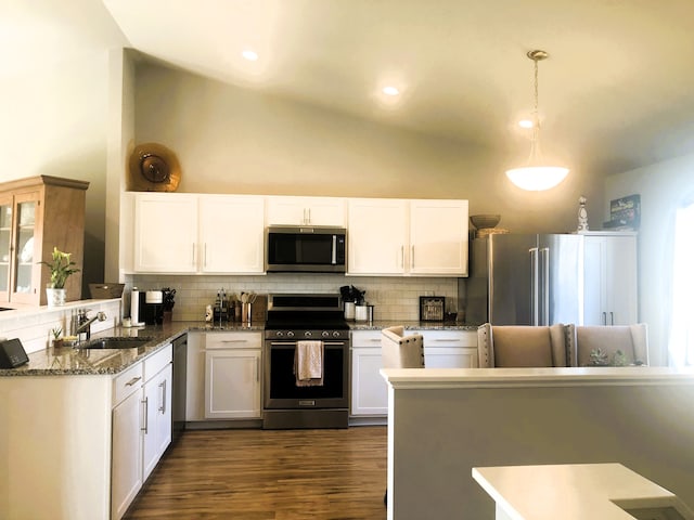 kitchen with stone countertops, dark wood-type flooring, white cabinetry, appliances with stainless steel finishes, and backsplash