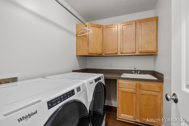 laundry area with cabinet space, a sink, dark wood-style floors, and washer and clothes dryer