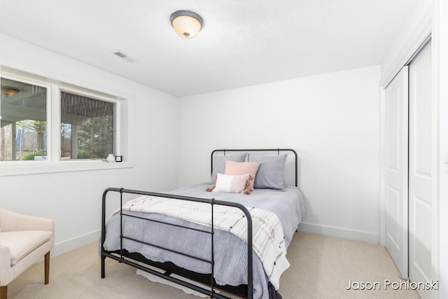 bedroom featuring carpet floors, baseboards, a closet, and visible vents