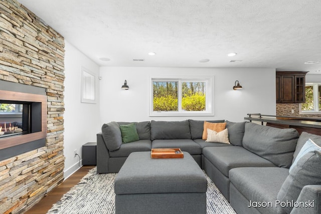 living room with visible vents, recessed lighting, and dark wood finished floors