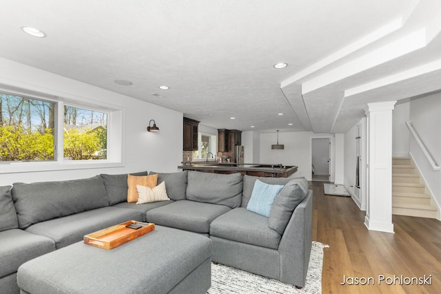 living area featuring stairs, dark wood-style flooring, and recessed lighting