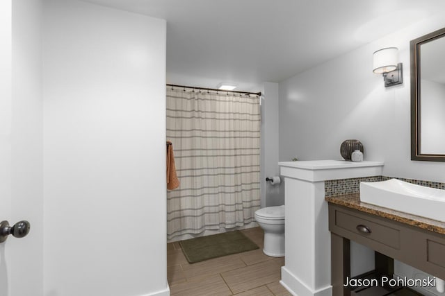 full bathroom with vanity, toilet, and curtained shower