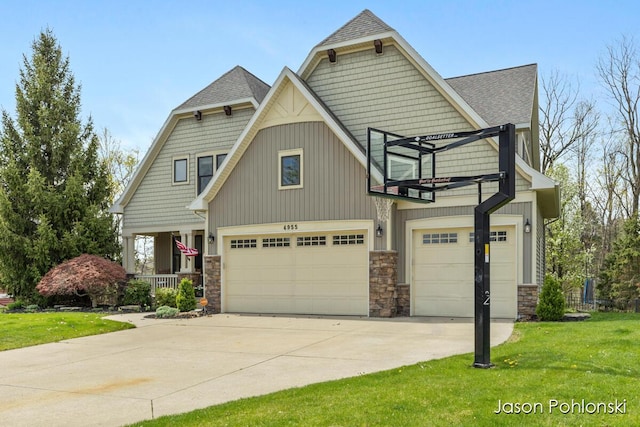 craftsman house with roof with shingles, concrete driveway, a front lawn, and stone siding