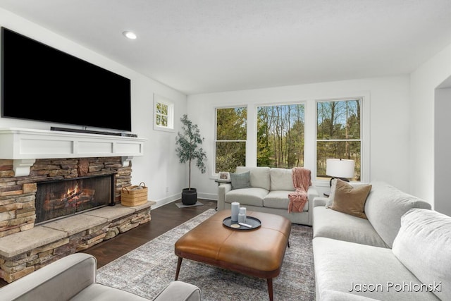 living area featuring baseboards, a fireplace, recessed lighting, and dark wood-type flooring